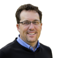 Mark Marrott with glasses in casual professional attire against a blurred natural outdoor background.